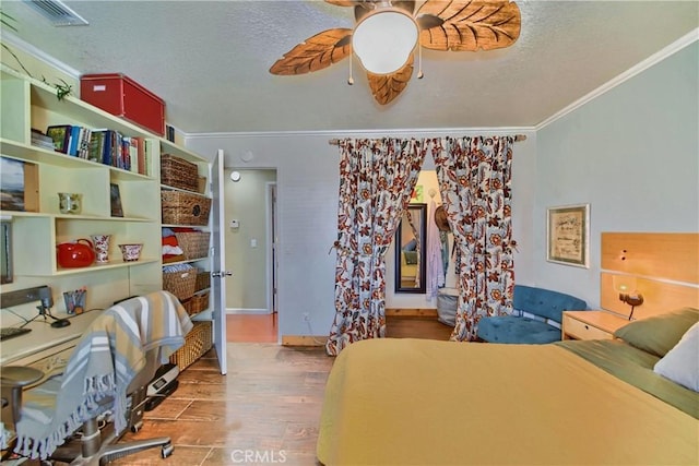 home office with wood finished floors, visible vents, ceiling fan, ornamental molding, and a textured ceiling