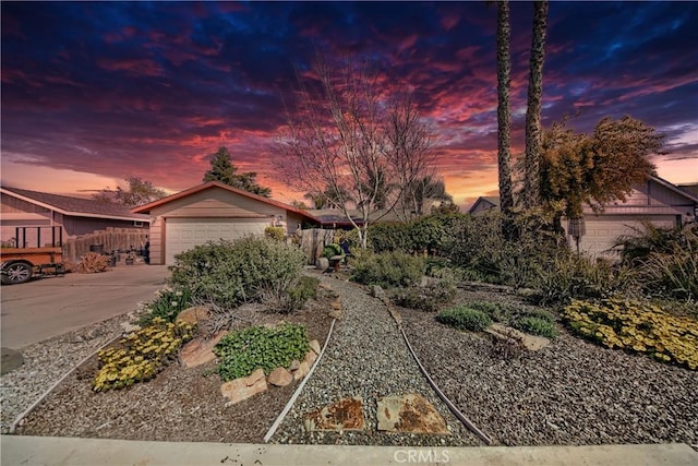 view of front of home featuring an attached garage, fence, and driveway