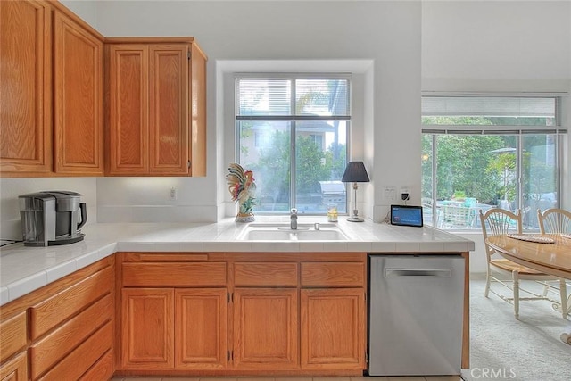 kitchen featuring a sink, brown cabinets, carpet, and stainless steel dishwasher