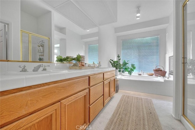 full bath featuring double vanity, a garden tub, a shower stall, and a sink