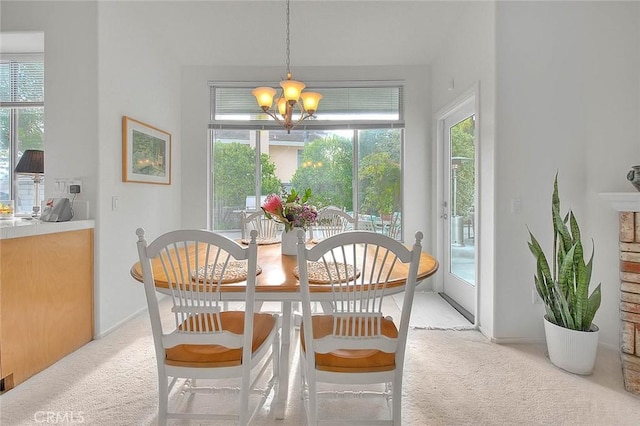 dining space featuring light carpet, a chandelier, and a wealth of natural light