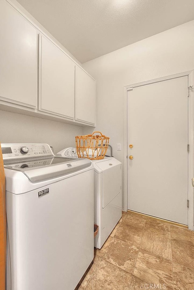 laundry room featuring washing machine and clothes dryer and cabinet space