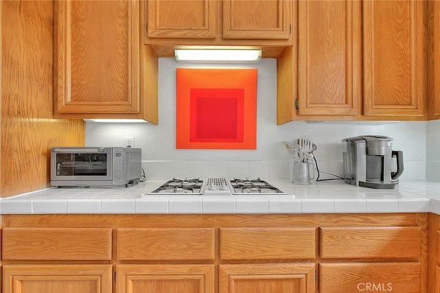 kitchen with light countertops, a toaster, and white gas stovetop