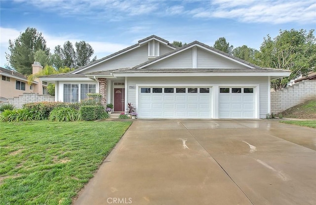 view of front of home featuring a front yard, an attached garage, driveway, and fence