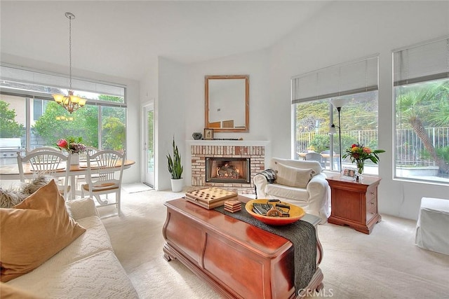 living area featuring a wealth of natural light, a fireplace, lofted ceiling, and an inviting chandelier