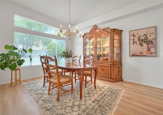 dining room with light wood-style floors, baseboards, and a chandelier