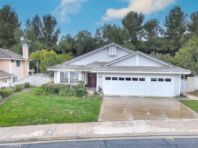 view of front facade with a front yard, fence, a garage, and driveway