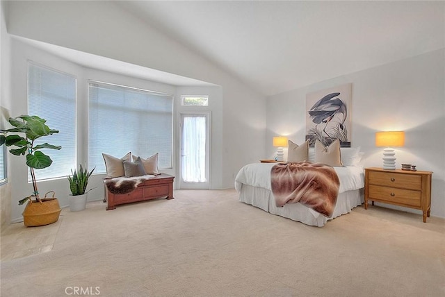 bedroom with multiple windows, lofted ceiling, and carpet floors