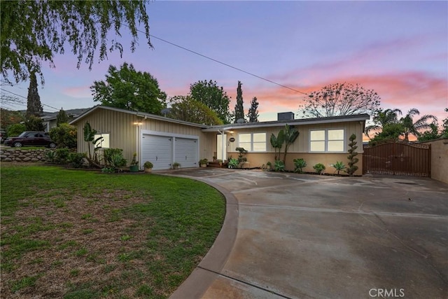 view of front of house with driveway, a front yard, a garage, and a gate