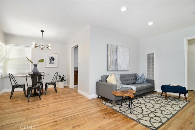 living area featuring a chandelier, recessed lighting, light wood-type flooring, and baseboards