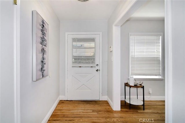 entryway with baseboards and wood finished floors