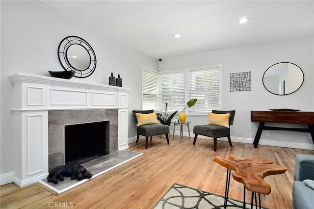 living area featuring recessed lighting, a fireplace, baseboards, and light wood finished floors