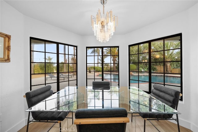 dining area featuring baseboards, a notable chandelier, and wood finished floors