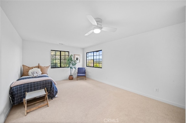 carpeted bedroom with ceiling fan and baseboards