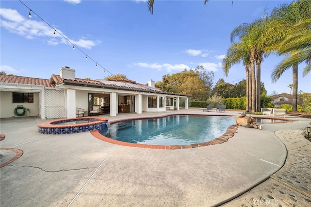 view of swimming pool featuring a pool with connected hot tub and a patio