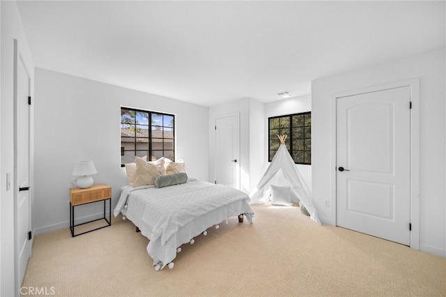 bedroom featuring baseboards and light carpet