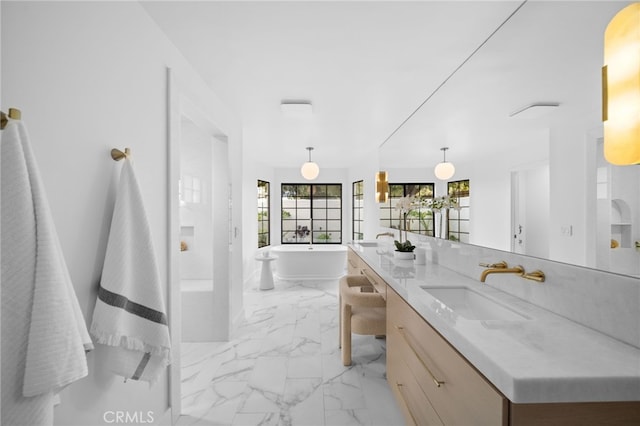 full bath with a soaking tub, marble finish floor, and vanity