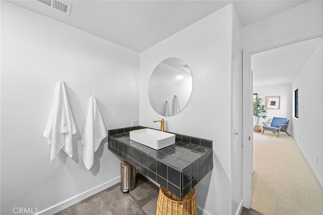 bathroom with visible vents, baseboards, and a sink