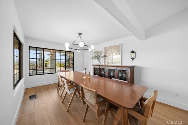 dining room with visible vents, beamed ceiling, an inviting chandelier, light wood finished floors, and baseboards