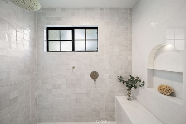 bathroom with built in features and a tile shower