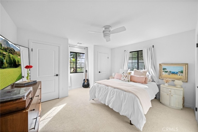 bedroom with visible vents, multiple windows, light carpet, and ceiling fan