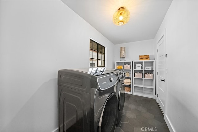 laundry area featuring dark tile patterned floors, laundry area, and separate washer and dryer