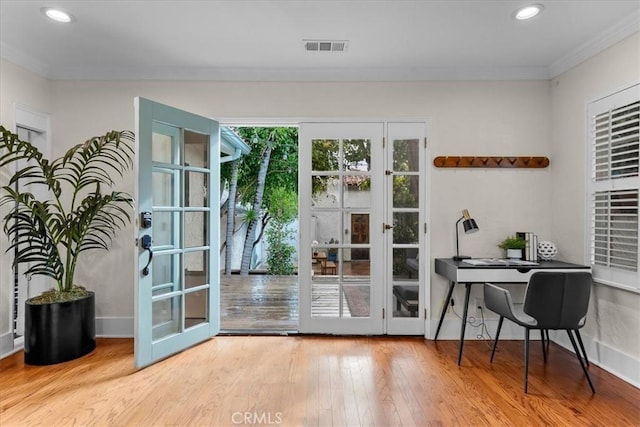 doorway to outside featuring visible vents, ornamental molding, french doors, and hardwood / wood-style flooring