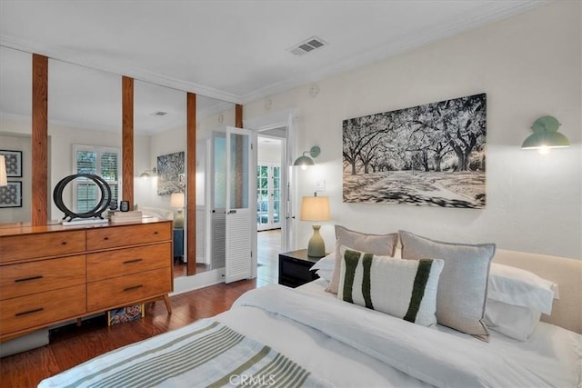 bedroom featuring crown molding, wood finished floors, and visible vents