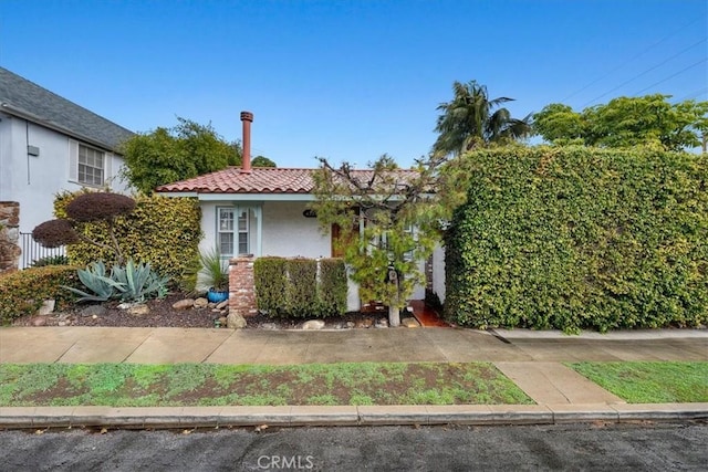 view of front of property featuring stucco siding and a tile roof