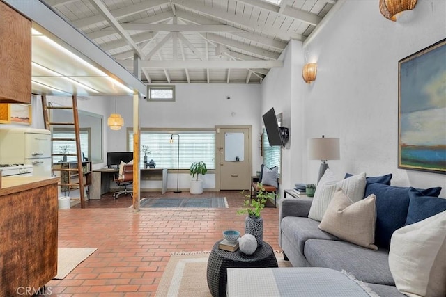 living area with wooden ceiling, beamed ceiling, brick floor, and high vaulted ceiling