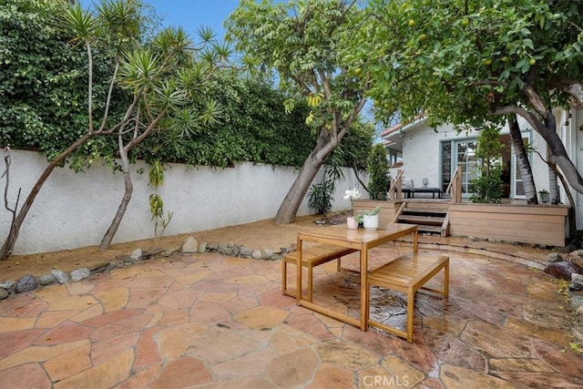 view of patio with a wooden deck and fence