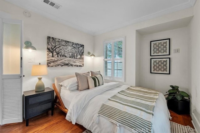 bedroom with wood finished floors and visible vents