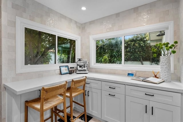 bar with recessed lighting and backsplash