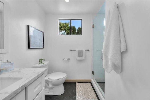 bathroom with vanity, baseboards, a stall shower, tile patterned flooring, and toilet