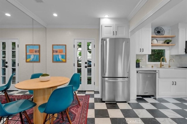 kitchen with french doors, appliances with stainless steel finishes, dark floors, light countertops, and crown molding