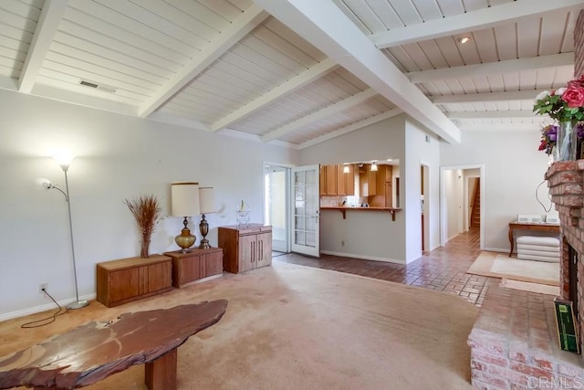 living area with visible vents, lofted ceiling with beams, carpet flooring, brick floor, and baseboards