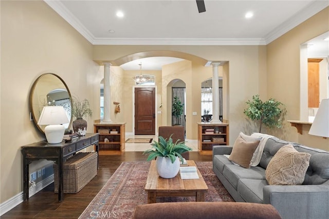 living area featuring arched walkways, baseboards, dark wood-type flooring, and ornate columns