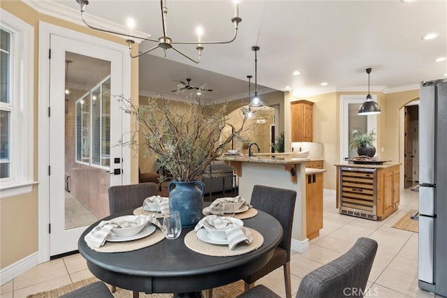 dining space with beverage cooler, light tile patterned floors, arched walkways, and ornamental molding