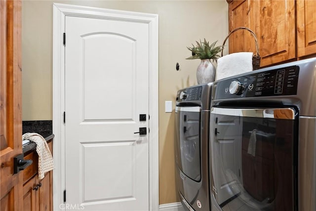 washroom with cabinet space and washing machine and dryer