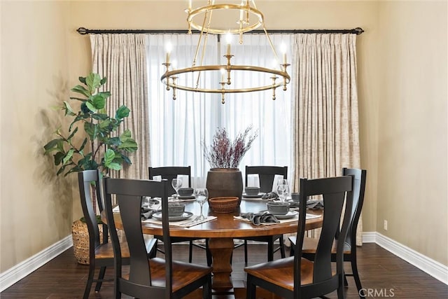 dining space featuring a chandelier, baseboards, and wood finished floors