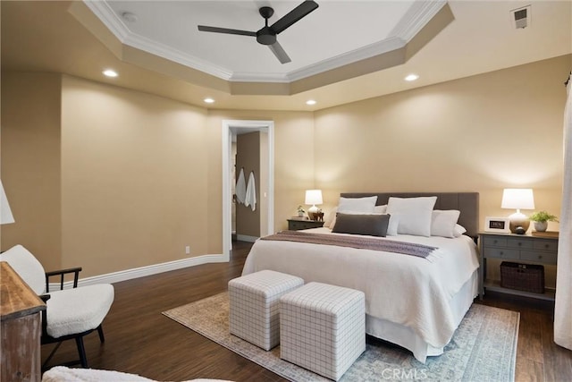 bedroom with visible vents, a raised ceiling, ornamental molding, wood finished floors, and baseboards