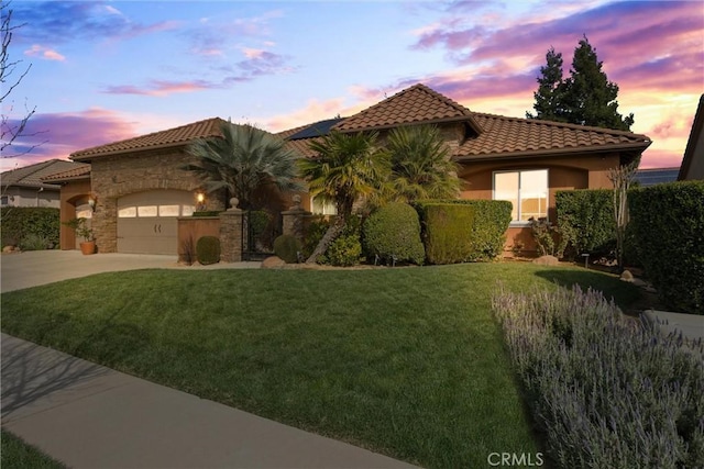 mediterranean / spanish house featuring a tile roof, an attached garage, driveway, and stucco siding