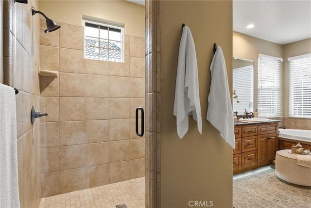 bathroom with a bath, plenty of natural light, a stall shower, and vanity