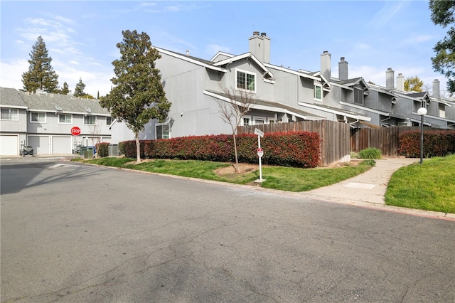 view of property featuring cooling unit, fence, and a residential view