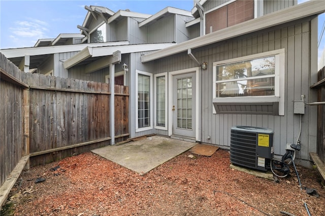 entrance to property with cooling unit, a patio, and fence