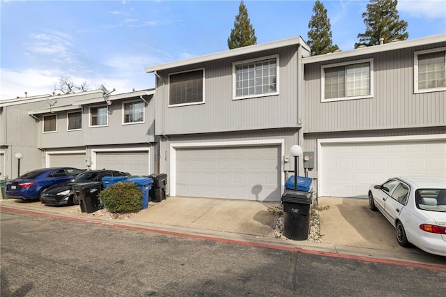 view of property with a garage and driveway