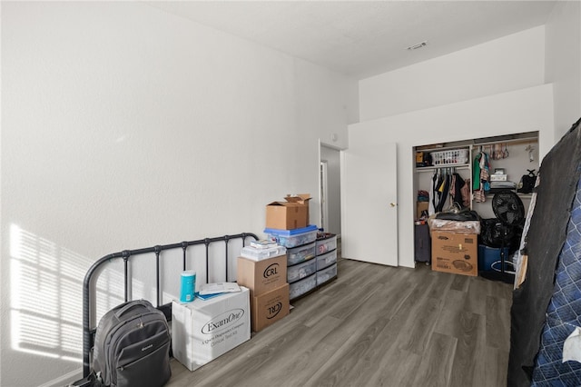 bedroom featuring visible vents, a closet, and wood finished floors