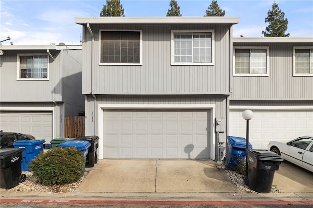 multi unit property featuring an attached garage and driveway