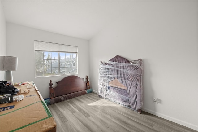 office space featuring lofted ceiling, baseboards, and wood finished floors