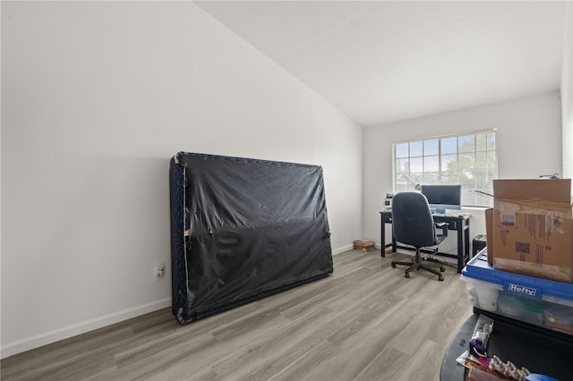 home office with baseboards, lofted ceiling, and wood finished floors